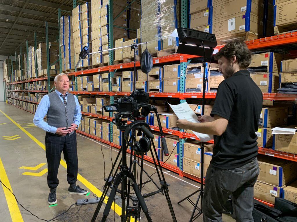 Video Crew filming businessman in warehouse